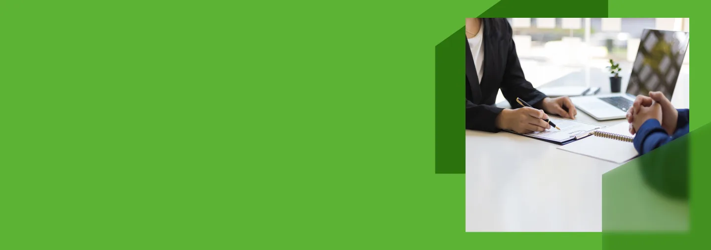 An image of two people sat at a desk conducting an interview, inside green geometric shapes